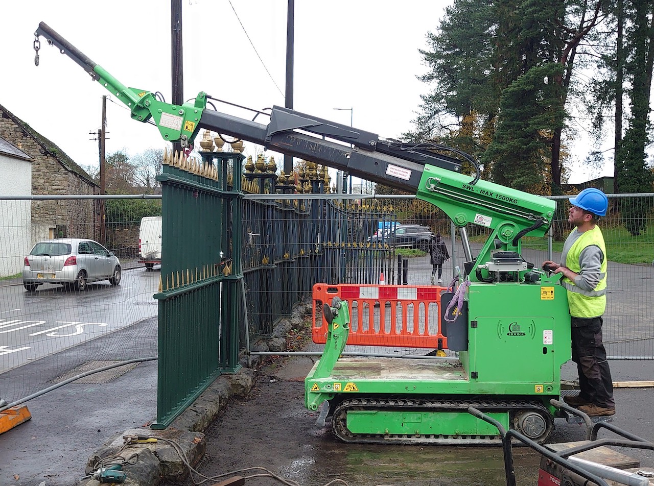 Here a section of repaired cast iron railing is being lowered carefully in place for installation
